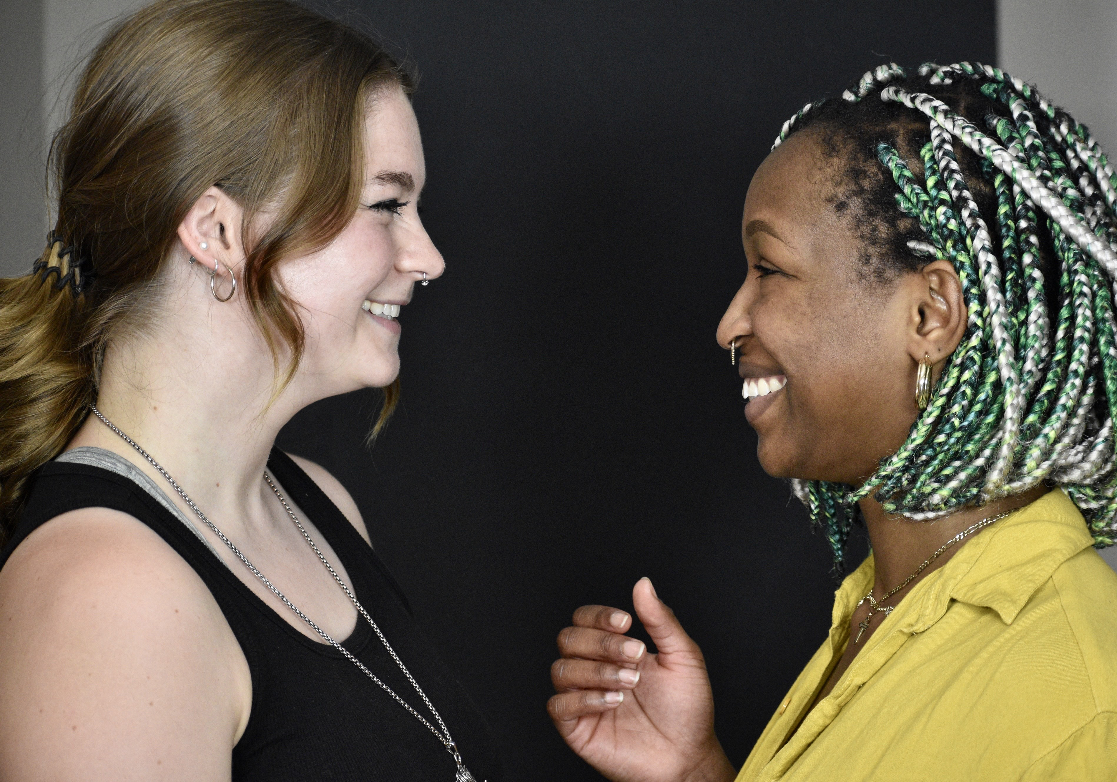 Two women smile at each other